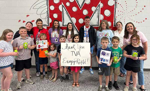 Children and adults holding artwork and a “Thank You TVA EnergyRight!” sign.