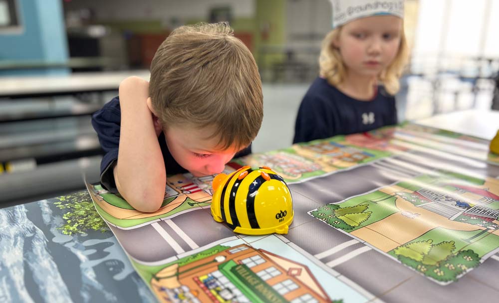 Two kids with a bee robot